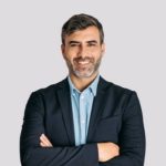 Front view of businessman smiling with arms crossed on white background